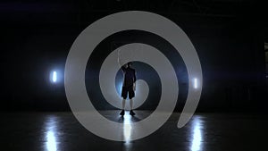 Skill dribbling basketball player in the dark on the basketball court with backlit back in the smoke. Slow motion