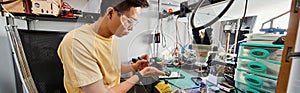 skilled asian technician in goggles working