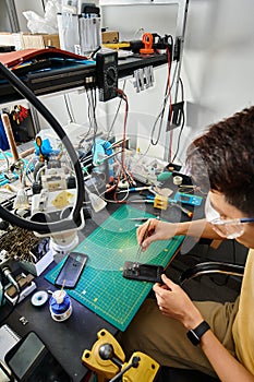 skilled asian technician in goggles working