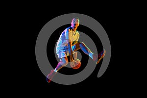 Skilled, athlete man, basketball player mid-air dribbling in motion against black studio background in mixed neon light.