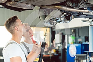 Skilled auto mechanic replacing the shock absorbers of a car