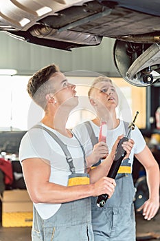 Skilled auto mechanic replacing the shock absorbers of a car