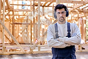 skilled builder architect man in headset posing against New residential construction home