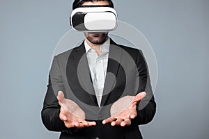 Skilled business man with suit holding something while VR goggle. Deviation.