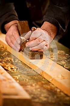 Skilled carpenter using a handheld plane photo