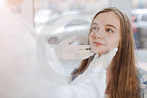 Skilled dermatologist examining patient skin in the clinic