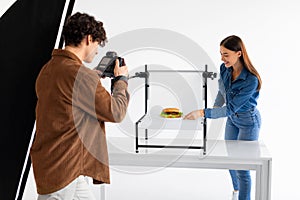 Food photographer captures burger with assistant styling