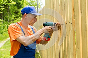 Skilled handiman tightening screws in wooden board photo