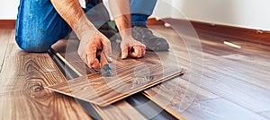 Skilled man s hands expertly installing laminate flooring for a home renovation project photo