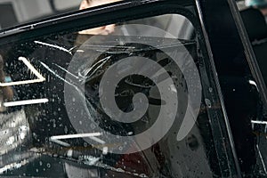 Skilled mechanic installing protection film on windshield