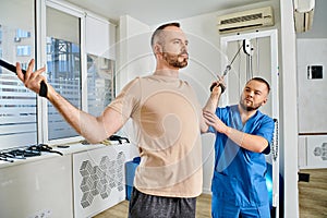 skilled physician helping man in sportswear