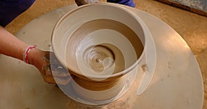 Skilled potter hands shaping the clay on potter wheel. Pot throwing handicraft bowl, jar, pot, jug. Rajasthan, India