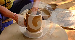 Skilled potter hands shaping the clay on potter wheel. Pot throwing handicraft bowl, jar, pot, jug. Rajasthan, India