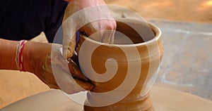 Skilled potter hands shaping the clay on potter wheel. Pot throwing handicraft bowl, jar, pot, jug. Rajasthan, India