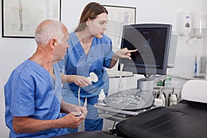 Skilled sonographer showing new equipment to assistant