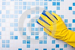 Skilled swabber is cleaning wall with a sponge