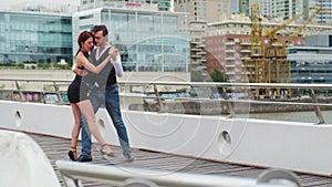 Skilled tango dancers moving with provocative steps over a bridge