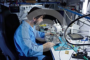 A skilled technician diligently repairing laptop while working under a microscope