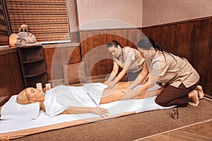 Skilled Thai massage therapists massaging female legs