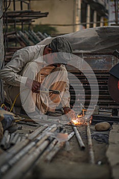 Skilled Welder welding metal pipes in Workshop