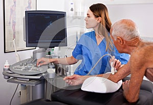 Skilled woman sonographer using ultrasonography machine checking