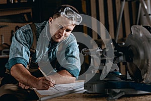 Skilled woodworker drawing new project photo