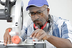 skilled woodworker using mitre saw