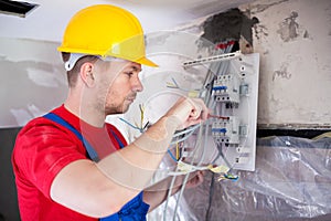 Skilled worker mounting automatic switches on distribution board