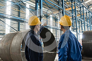 Skilled worker pointing up while giving instructions to an apprentice photo