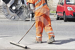 Skilled worker in road construction site with orange uniform
