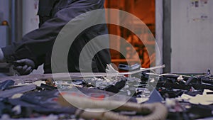 Skilled worker searches non-recyclable waste on conveyor belt at recycling plant slow motion