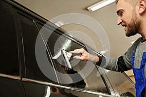 Skilled worker washing tinted car window