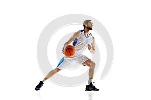 Skilled young man, basketball player in motion with ball demonstrating dribbling technique isolated on white background