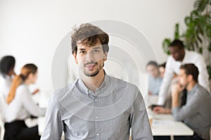 Skilled young professional looking at camera posing in office, p