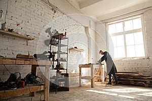 Spacious workshop interior with handyman working with power tool photo