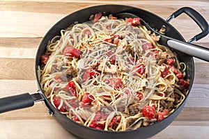 Skillet full of chicken, basil and tomato linguine