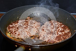 Skillet with greasy ground beef patties