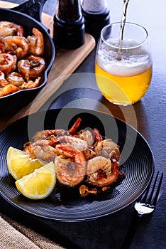 Skillet roasted jumbo shrimp on a black plate