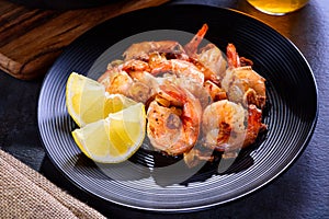 Skillet roasted jumbo shrimp on a black plate