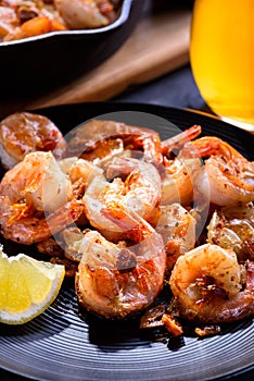 Skillet roasted jumbo shrimp on a black plate