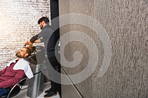 Skillful barber cleaning head of client