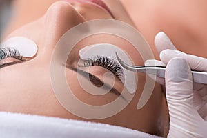 Skillful cosmetician making artificial eyelashes