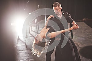 Skillful dancers performing in the dark room under the light