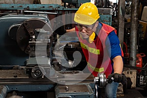 Skillful factory worker or engineer do machine job in manufacturing workshop