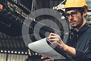 Skillful factory worker working with clipboard to do job procedure checklist .