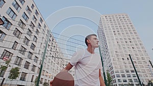 Skillful sportsman shows spectacular stunt or trick with ball on basketball play yard or court. Ball spinning and rotate