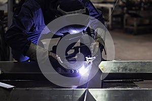 Skillful welders weld steel in the factory.