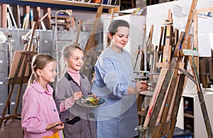 Skillful woman teacher showing her skills during painting class