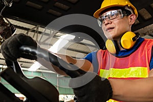 Skillful worker drives forklift in the factory .