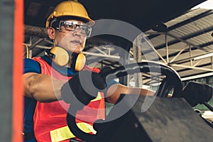 Skillful worker drives forklift in the factory .